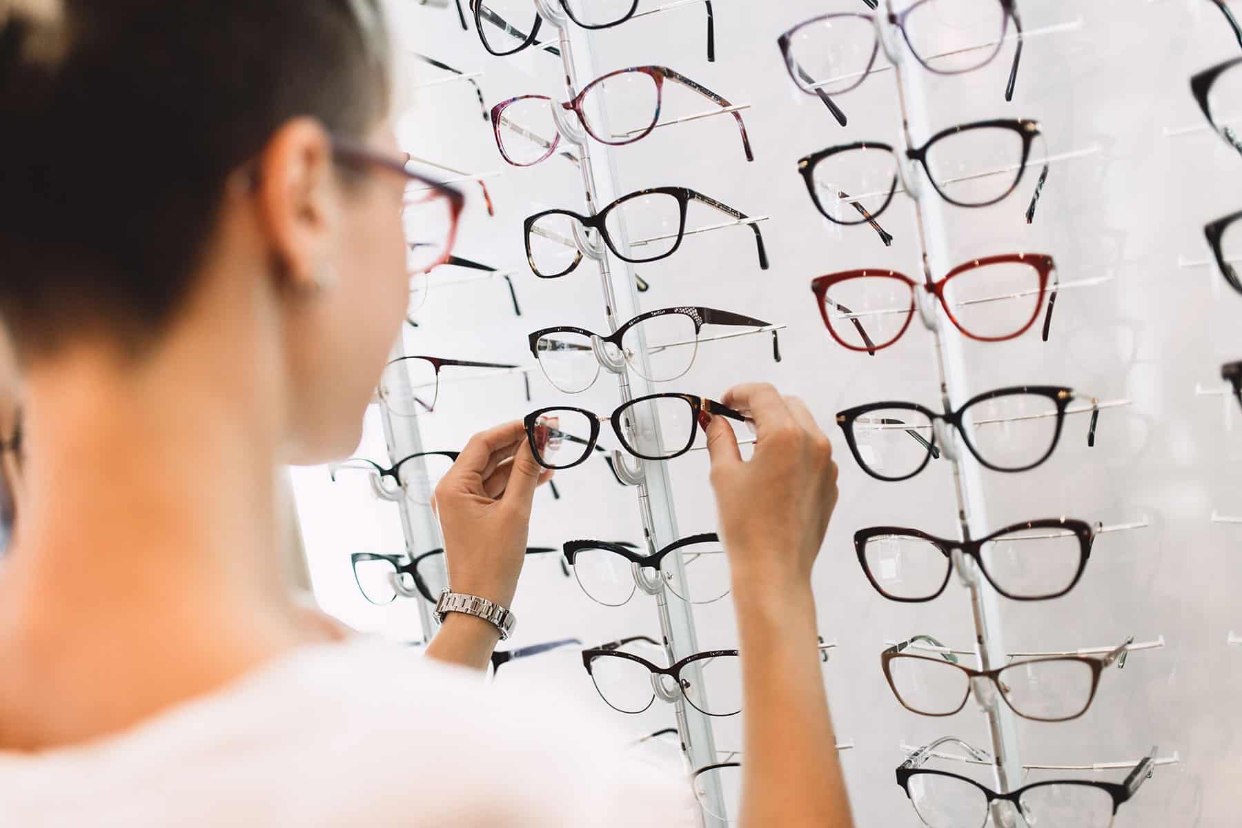 woman picking out eyeglasses